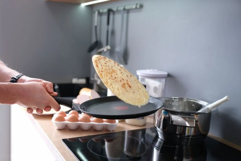 Man making thin pancakes Thin-battered crepes