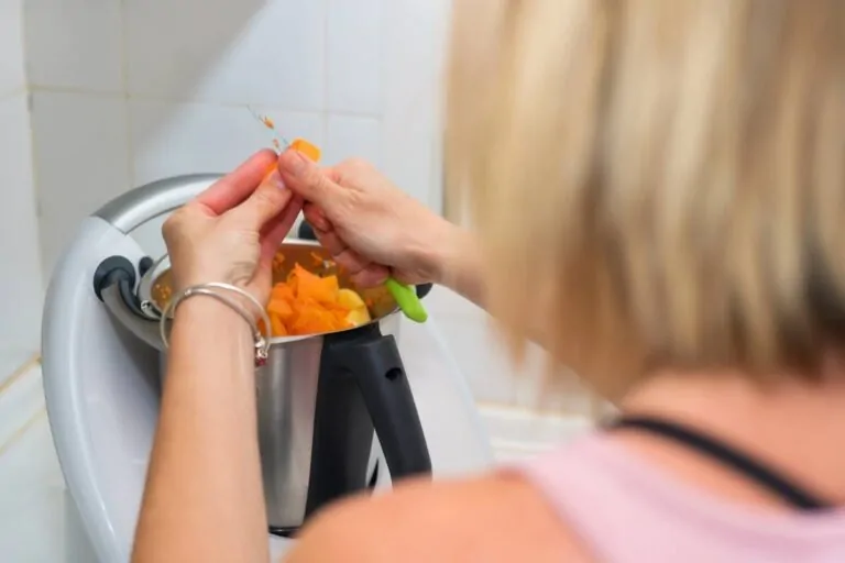 Zubereitung eines Rezepts mit einer Küchenmaschine Eine Frau bereitet ein Rezept mit einer Küchenmaschine zu