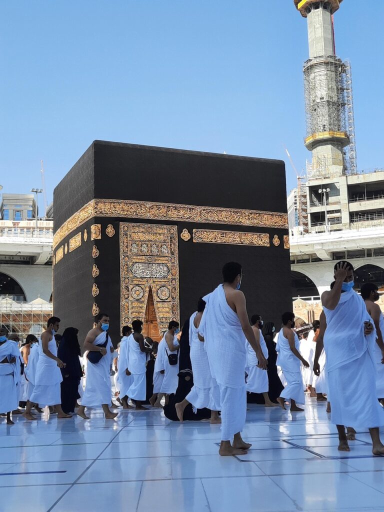 La Kaaba, con un grupo de hombres vestidos con ropa blanca de Ihram para la Umrah o el Hajj