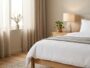 Minimalist wooden bedside table beside a white bed in a Scandinavian bedroom