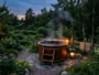 Bain nordique en bois installé dans un jardin avec eau chauffée fumante