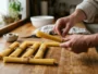 Portions de spaghetti crus mesurées à la main sur un plan de travail en bois