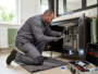 Professional plumber repairing a leak under a bathroom sink