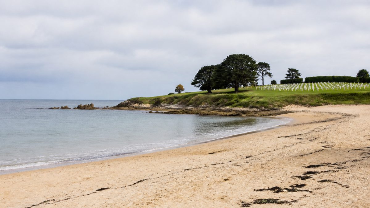 Bayeux et les plages du Débarquement, jour 3 Plage calme en Normandie avec rangées de croix blanches sur une pelouse en arrière-plan