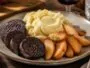 Boudin noir accompagné de purée maison et de pommes poêlées sur une table