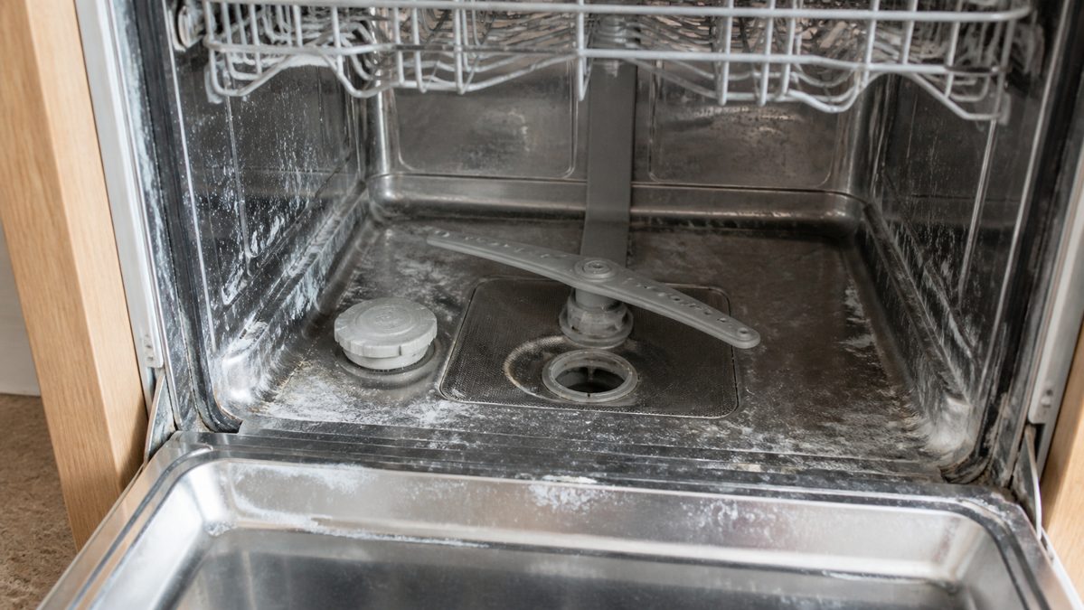 Calcaire et résidus dans le lave-vaisselle Dépôts de calcaire et résidus alimentaires visibles dans un lave-vaisselle