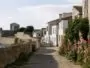 Cobbled alley in the fortified village of Île d'Aix with hollyhocks
