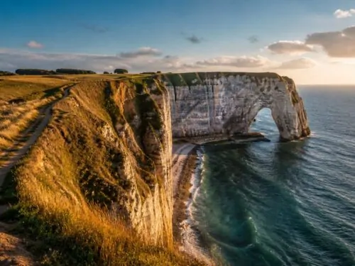 Falaises blanches et arche naturelle sur la côte normande au coucher du soleil