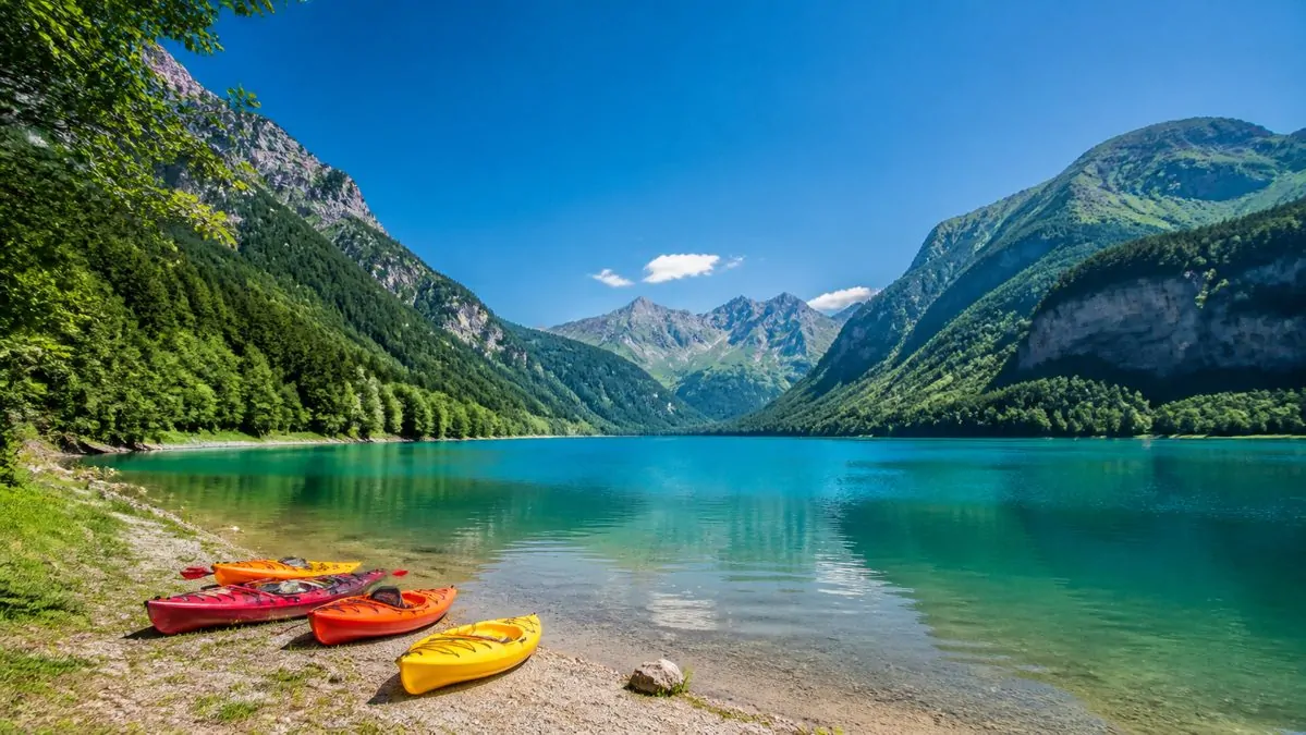 Visiter la Savoie hors ski, lac et montagnes en été Lac alpin turquoise entouré de montagnes en Savoie durant l'été