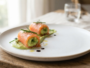 Assiette blanche avec une entrée chic au contraste de couleurs vert et rose, dressage soigné