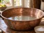 Bassine en cuivre terni trempant dans un bain de vinaigre blanc et de sel sur un plan de travail