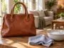 Sac en cuir posé près d'un chiffon doux et d'un bol d'eau savonneuse