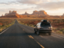 Voiture de location roulant sur une route déserte du sud-ouest américain au coucher du soleil