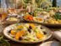 Salade fenouil orange au premier plan et grand aïoli garni sur une table provençale